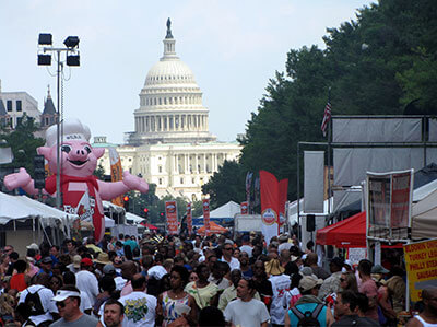 Inflatable Famous Dave's mascot Wilbur at an outdoor food festival with the U.S. Capitol building in the background