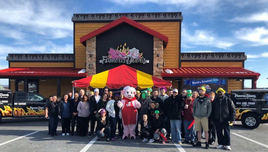 Famous Dave's BBQ Team and pig mascot stand in front of their DMV location
