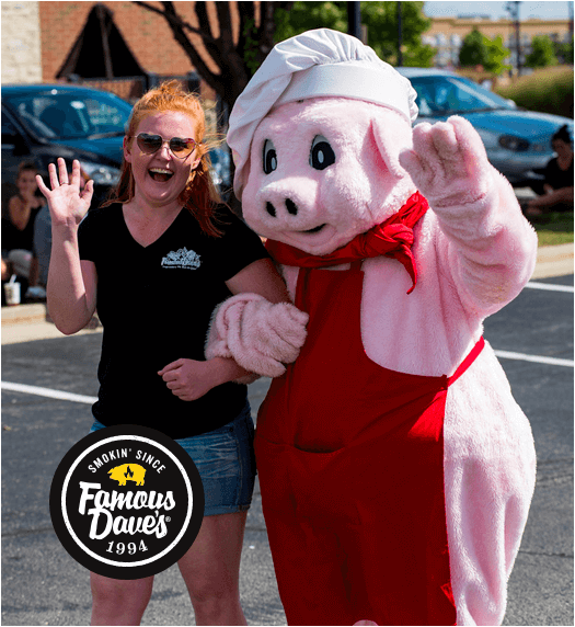 A team member and the Famous Dave's mascot wave for the camera